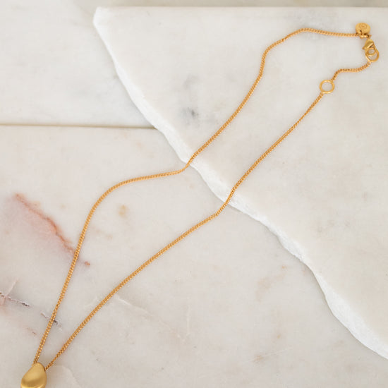 Gold necklace on a marble surface