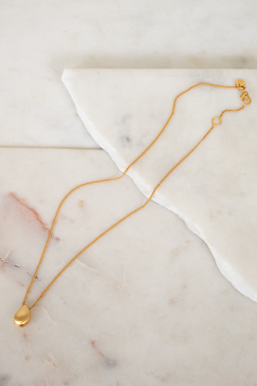 Gold necklace on a marble surface