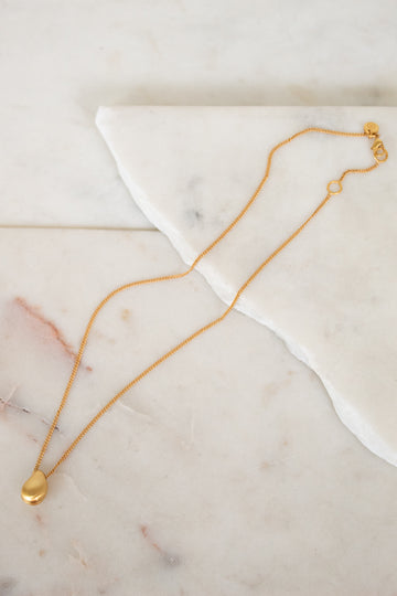 Gold necklace on a marble surface