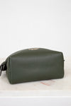 Base of green leather bag on a light marble surface