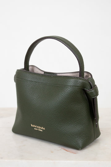 Green handbag with 'kate spade new york' logo on a white background