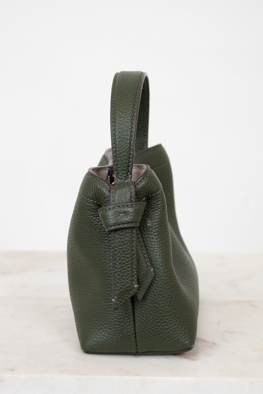 Green leather handbag on a white background