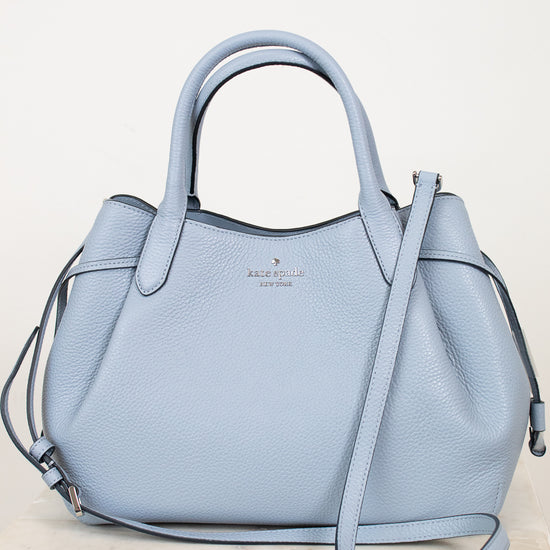 Light blue handbag with a strap on a white background