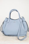 Light blue handbag with a strap on a white background