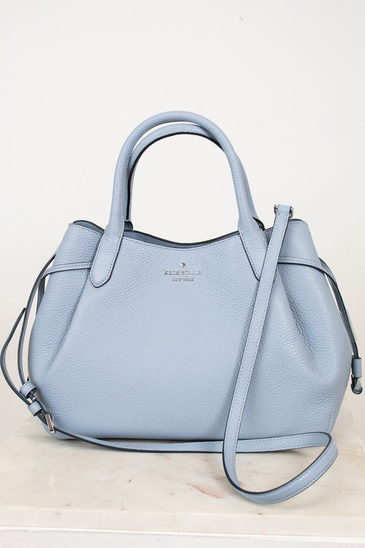 Light blue handbag with a strap on a white background