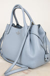Light blue handbag with a visible brand logo on a light background