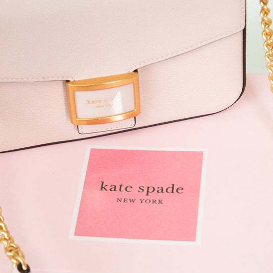 Pink handbag with gold chain detail and 'kate spade New York' label.