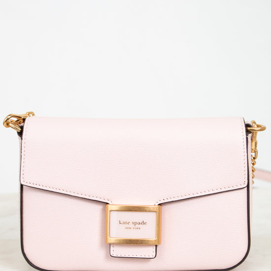 Pink handbag with gold accents on a white background