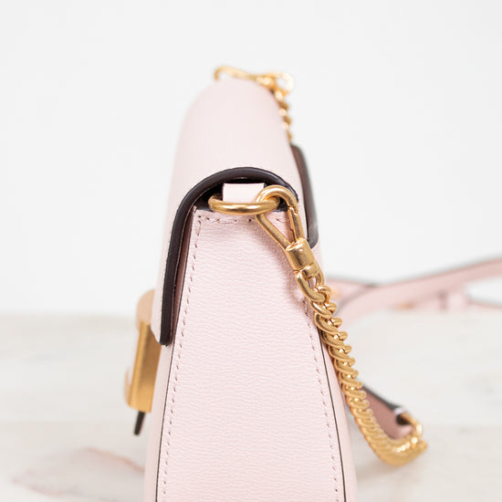 Pink handbag with gold chain on a white background