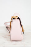 Pink handbag with gold chain detail on a white background