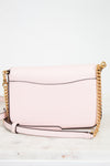 Pink handbag with gold chain strap on a white background