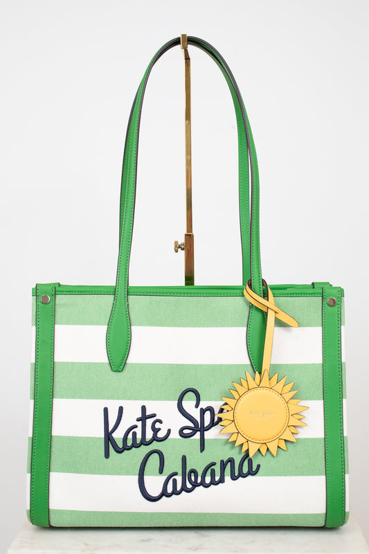 Green and white striped tote bag with 'Kate Spade Cabana' text and a sunflower charm on a white background.