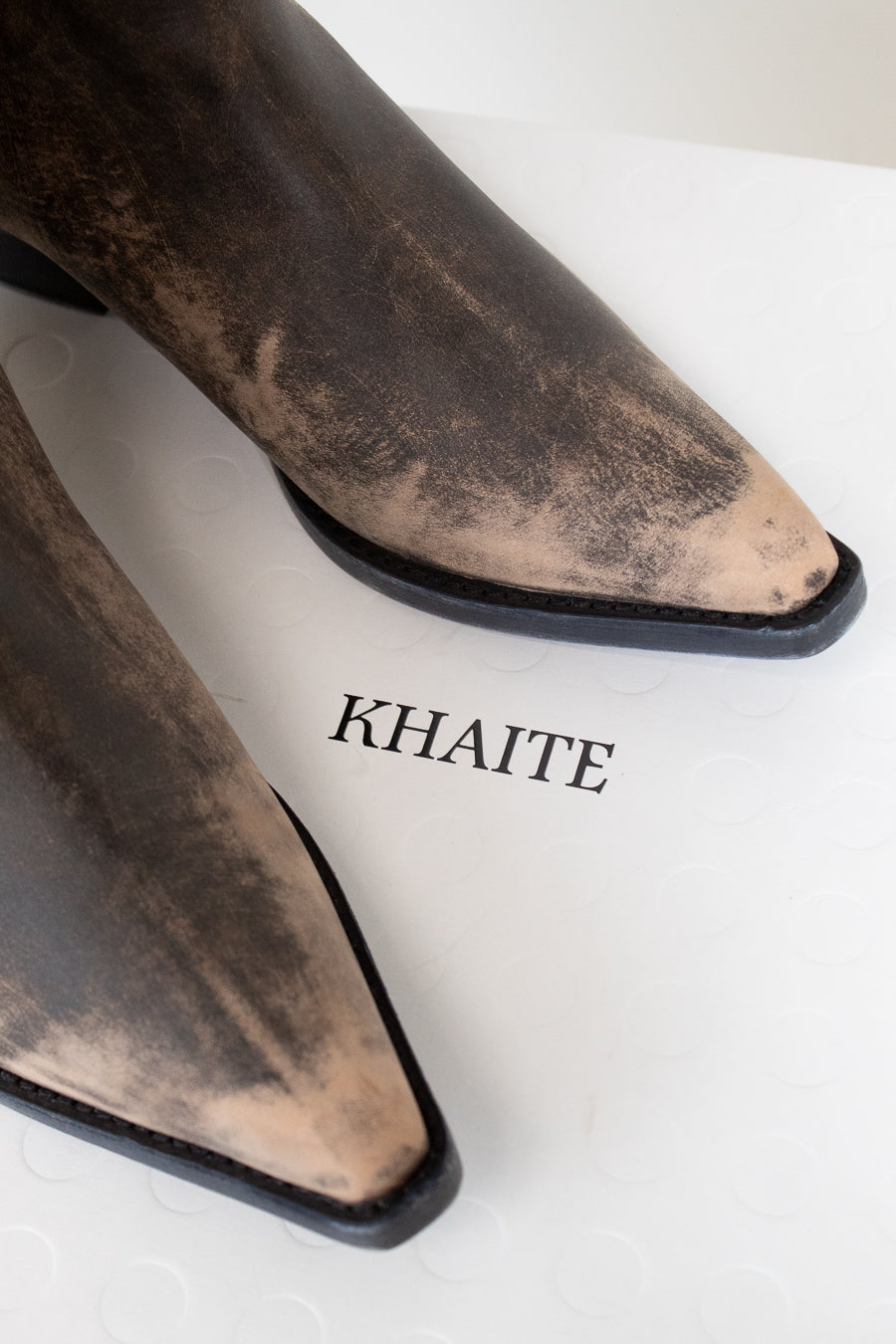 Brown pointed-toe boots with 'KHAITE' branding on a white background