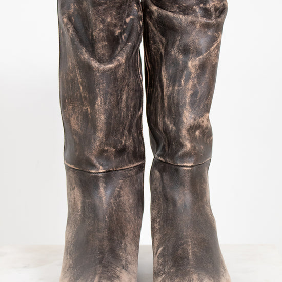 Pair of distressed brown boots on a white background
