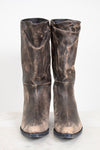 Pair of distressed brown boots on a white background