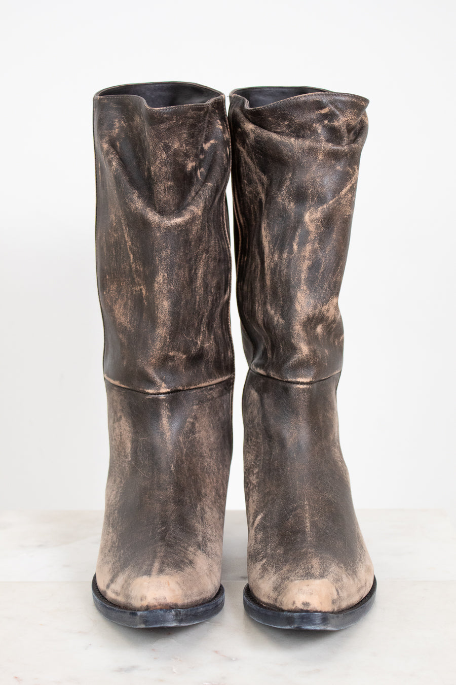 Pair of distressed brown boots on a white background