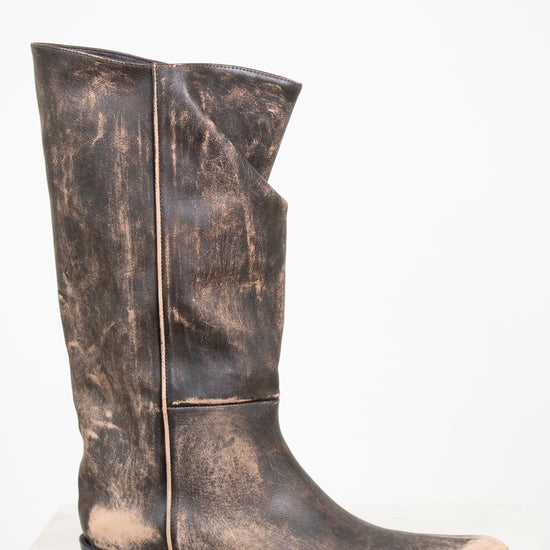 Distressed brown leather boot on a white background