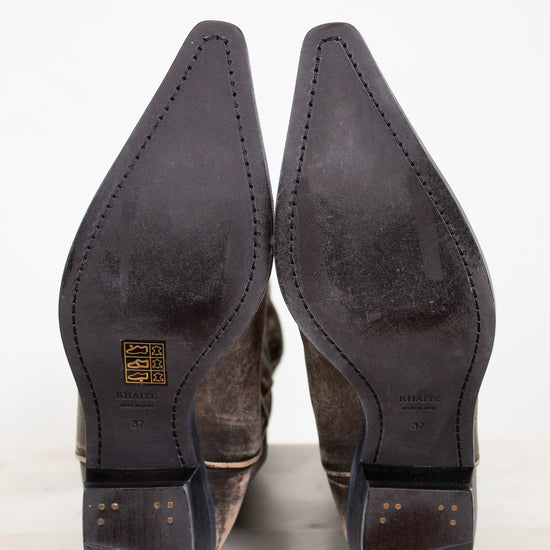 Close-up of brown leather shoes with pointed toes on a white background