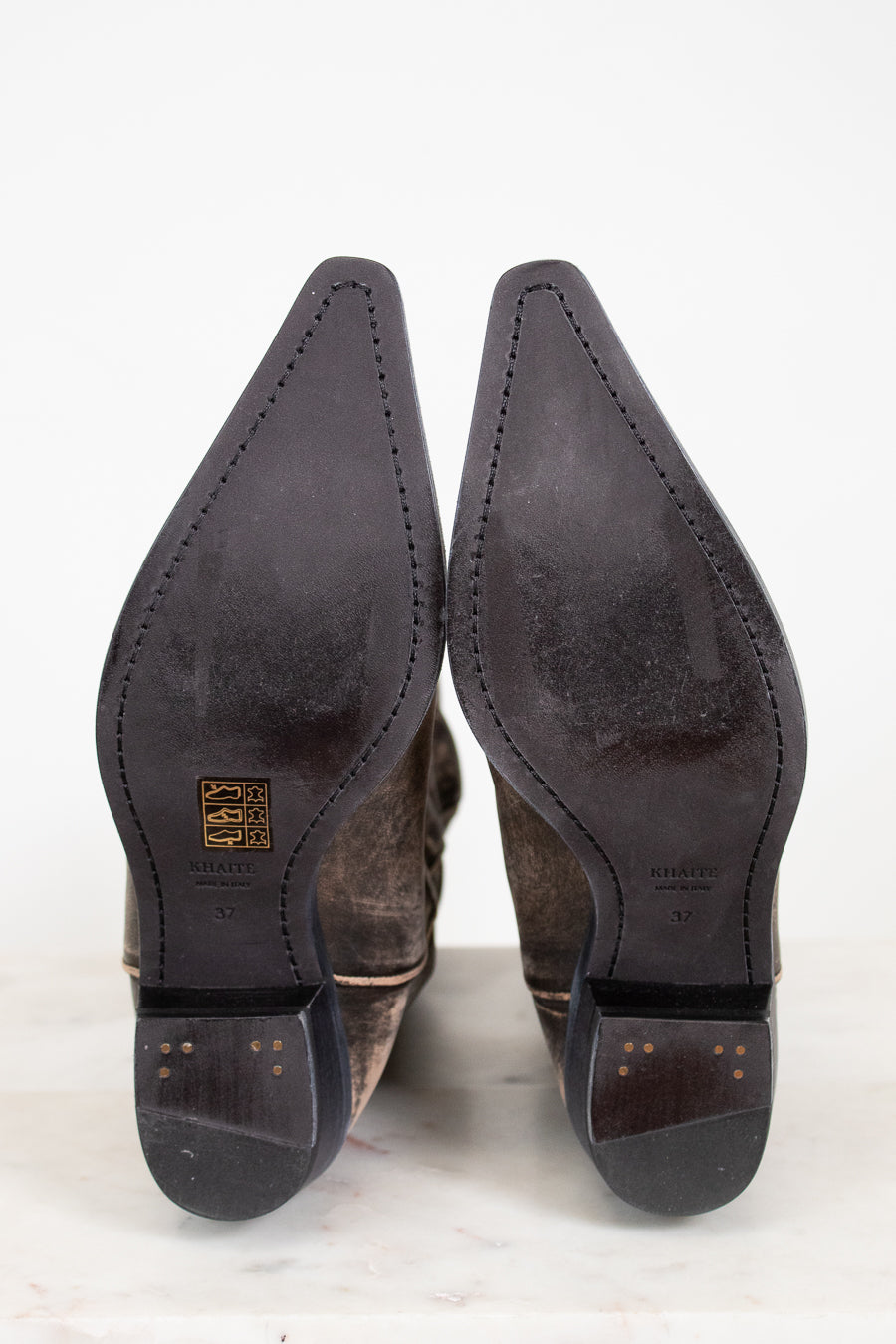 Close-up of brown leather shoes with pointed toes on a white background