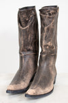 Pair of worn brown leather boots on a white background