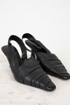 Pair of black leather slingback shoes on a light background