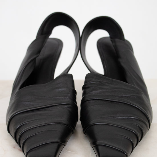 Pair of black strappy shoes on a light gray background