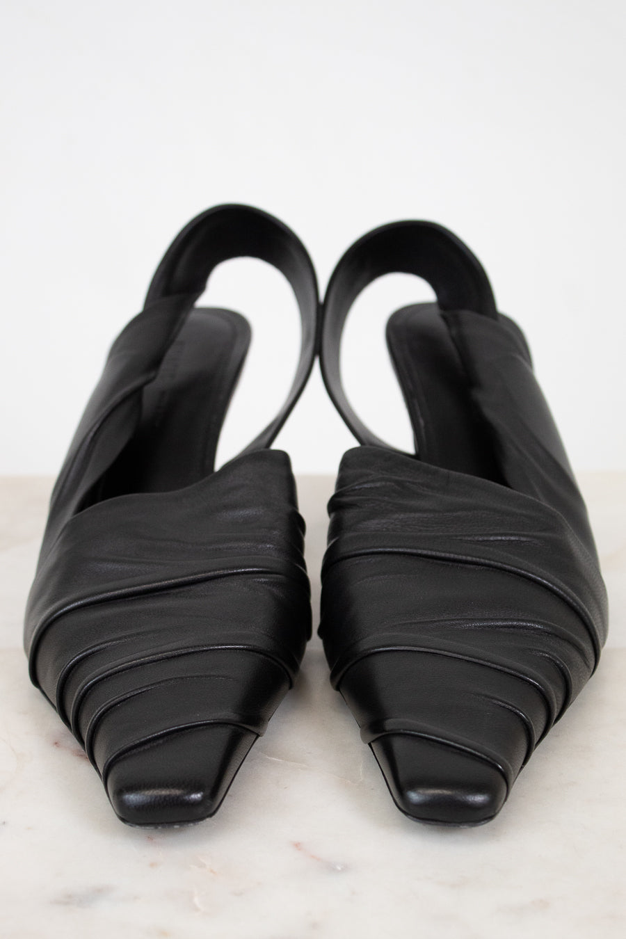 Pair of black strappy shoes on a light gray background