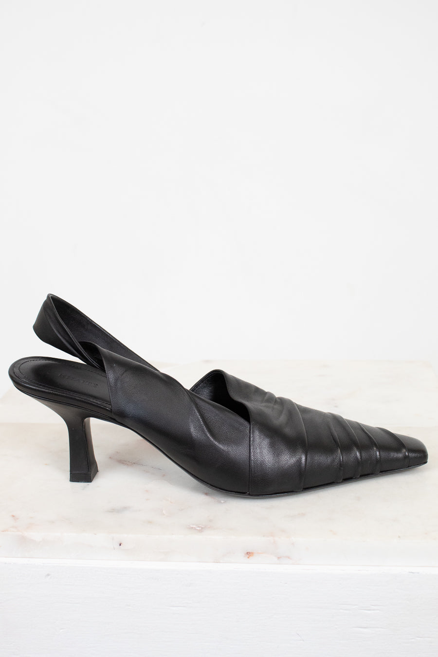 Pair of black leather slingback heels on a light background