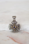 Silver and gold cross pendant on white background