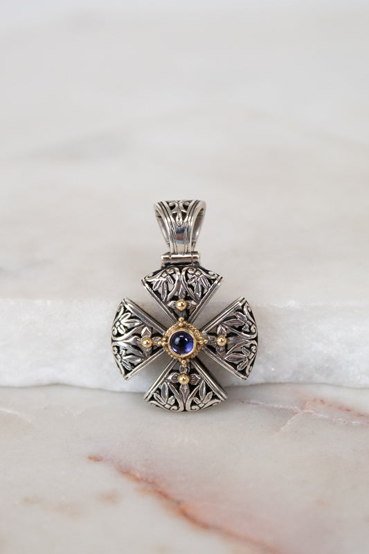 Silver and gold cross pendant on white background
