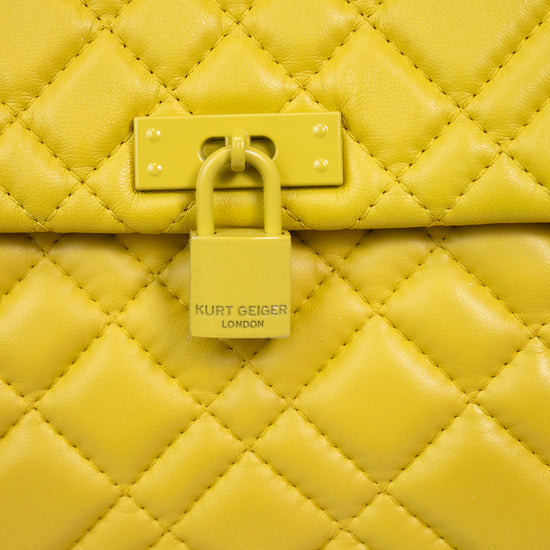 Yellow quilted handbag with a visible Kurt Geiger brand logo on a light background