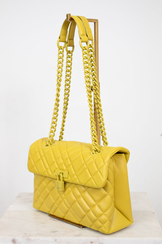 Yellow quilted handbag with chain strap on a white background
