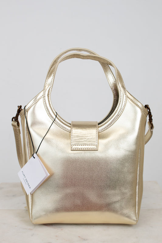Gold handbag with a tag on a light gray background
