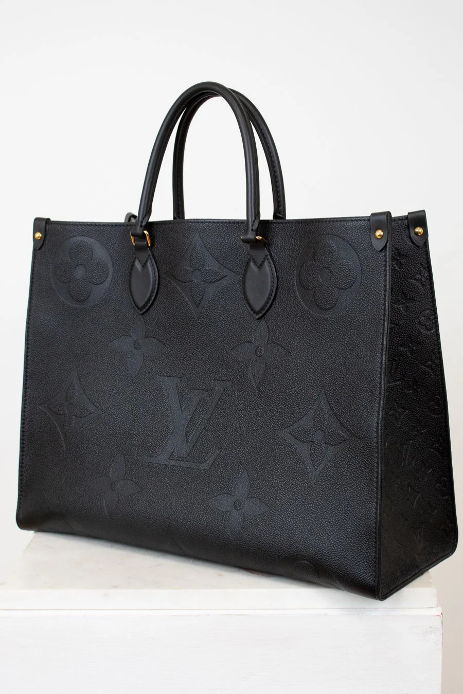 Black embossed handbag on a white background