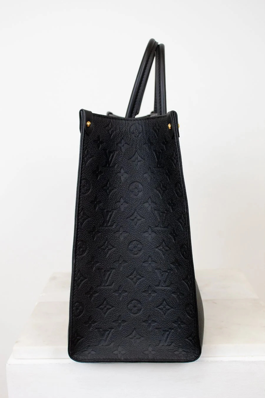Black embossed handbag on a white background