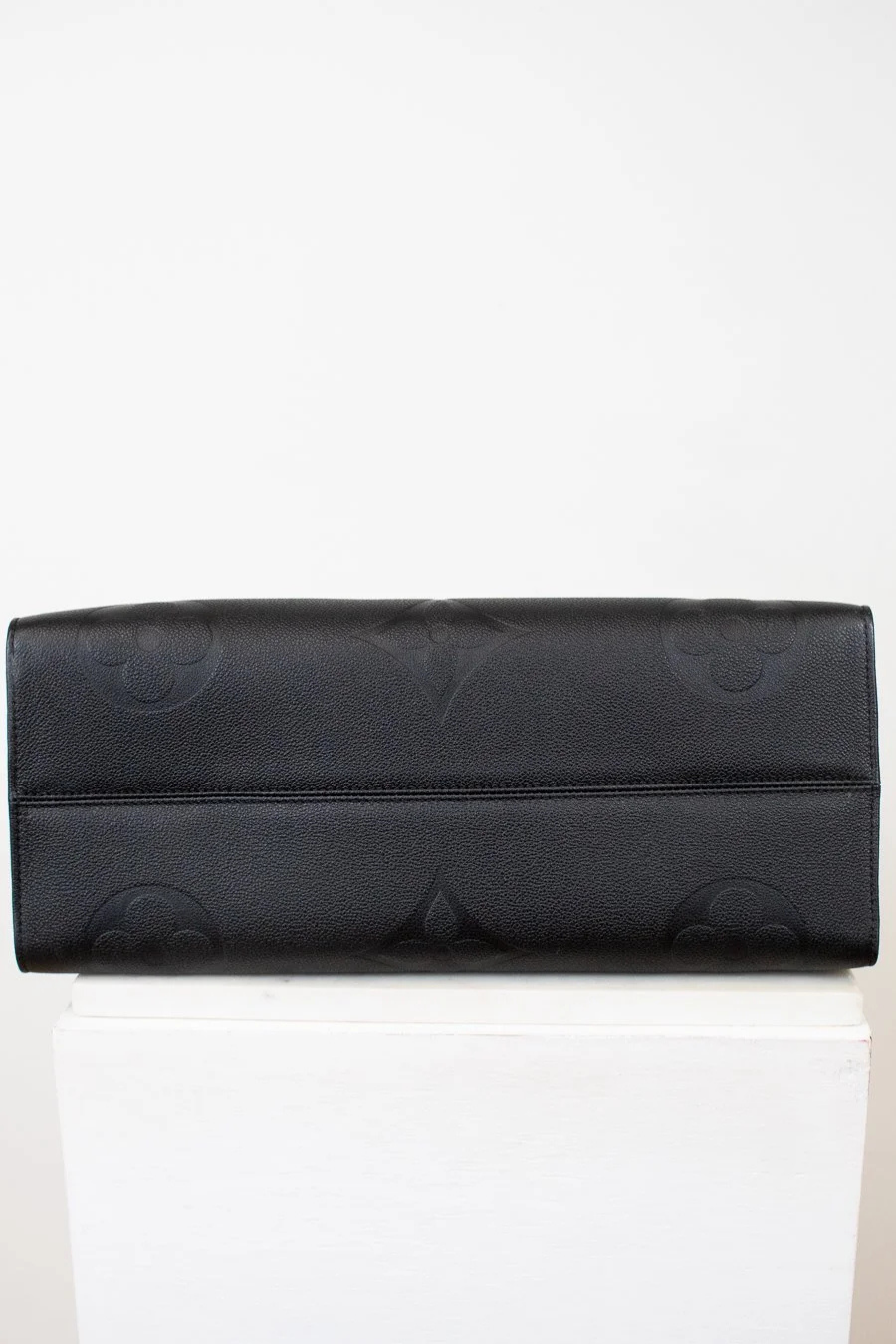 Bottom of black bag with a subtle pattern on a white background