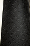 Close-up of a black leather wallet with embossed logo pattern