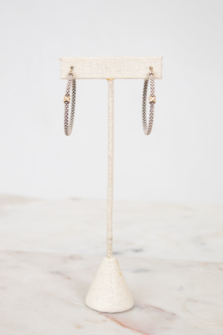 Jewelry stand with necklaces on a marble surface
