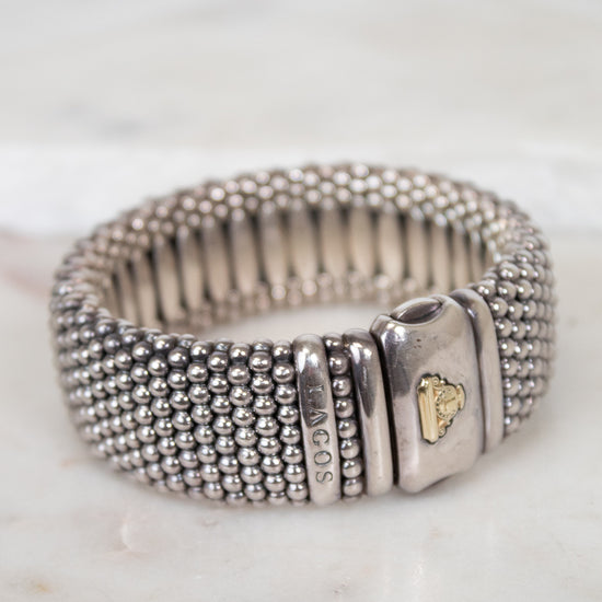 Silver beaded bracelet with a clasp on a light background