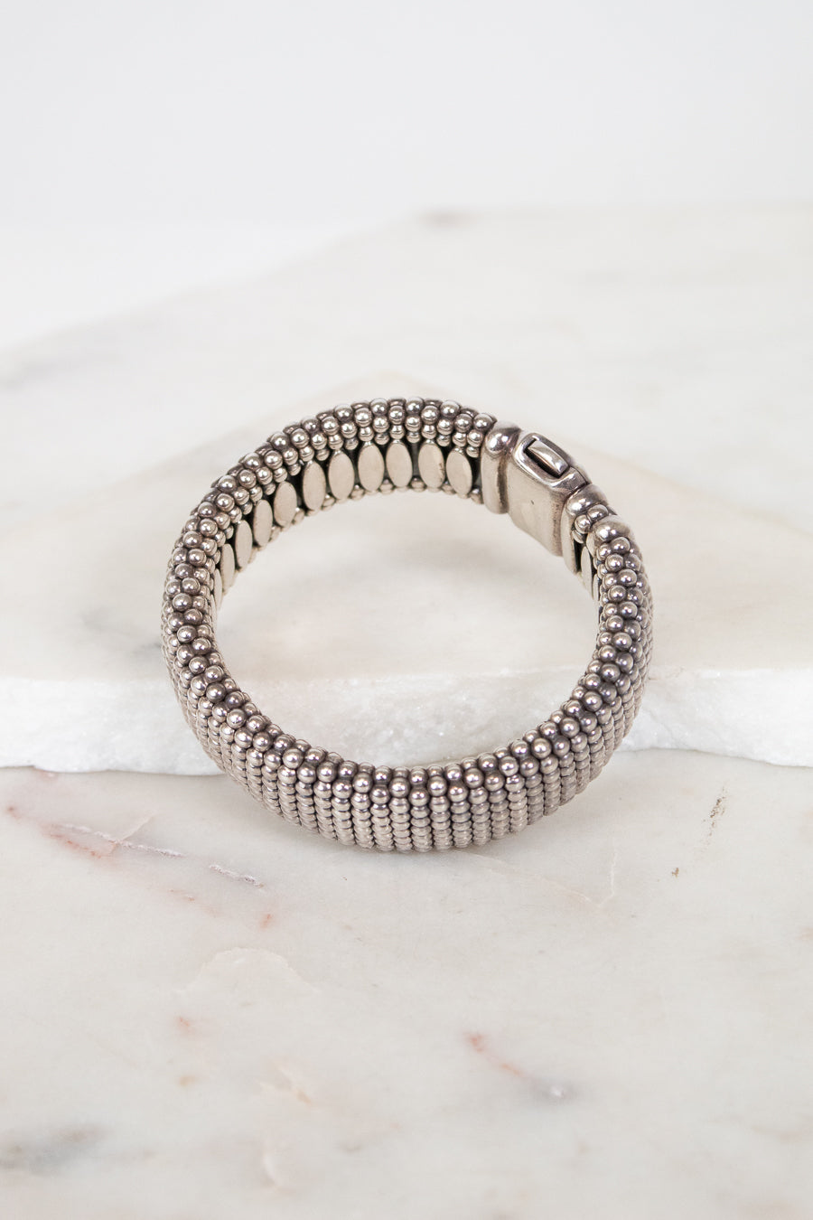 Silver beaded bracelet on a marble surface