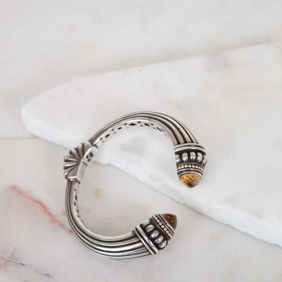 Silver bracelet with intricate design on a marble surface