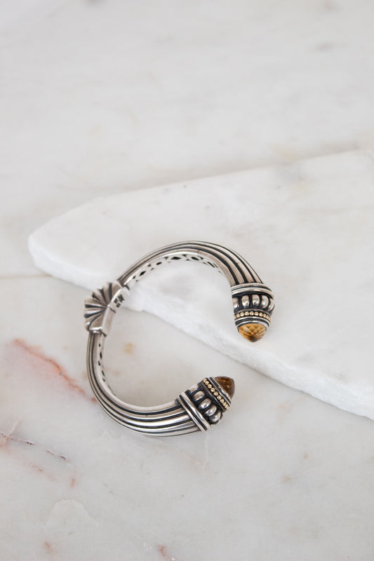 Silver bracelet with intricate design on a marble surface