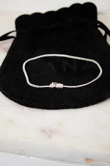 Bracelet on a black drawstring bag with 'LANA' branding on a marble surface