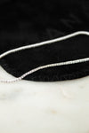 Silver and diamond bracelet on a black and white surface