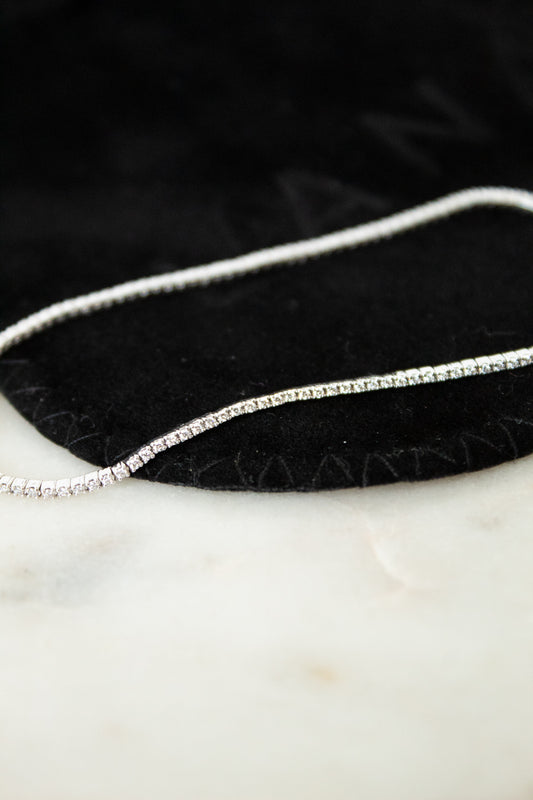 Silver and diamond bracelet on a black and white surface