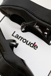 Close-up of a black and white product with 'Larroude' branding on a white background