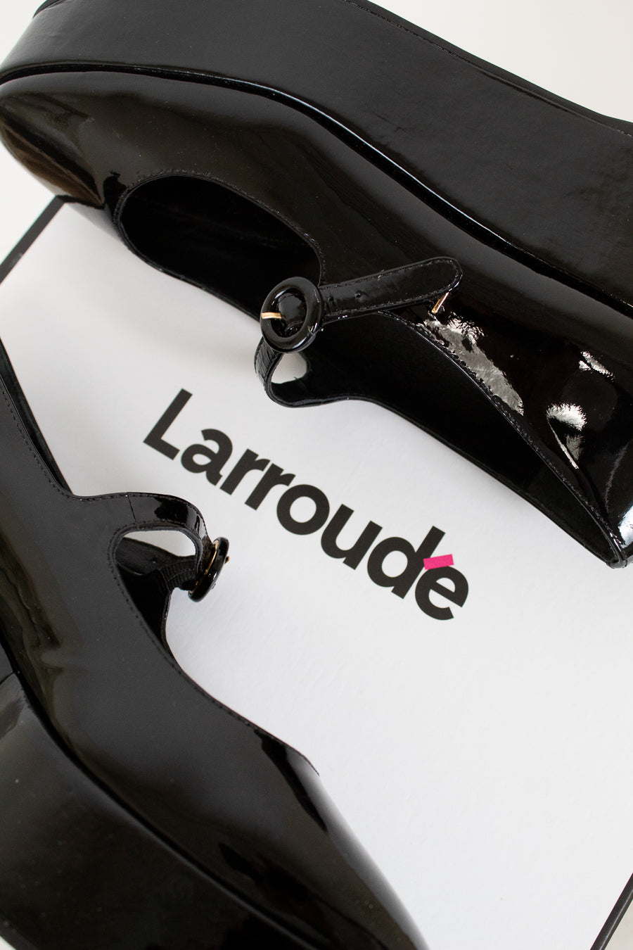 Close-up of a black and white product with 'Larroude' branding on a white background