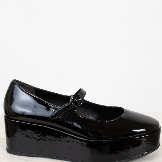 Black patent leather shoe on a light background