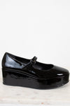 Black patent leather shoe on a light background