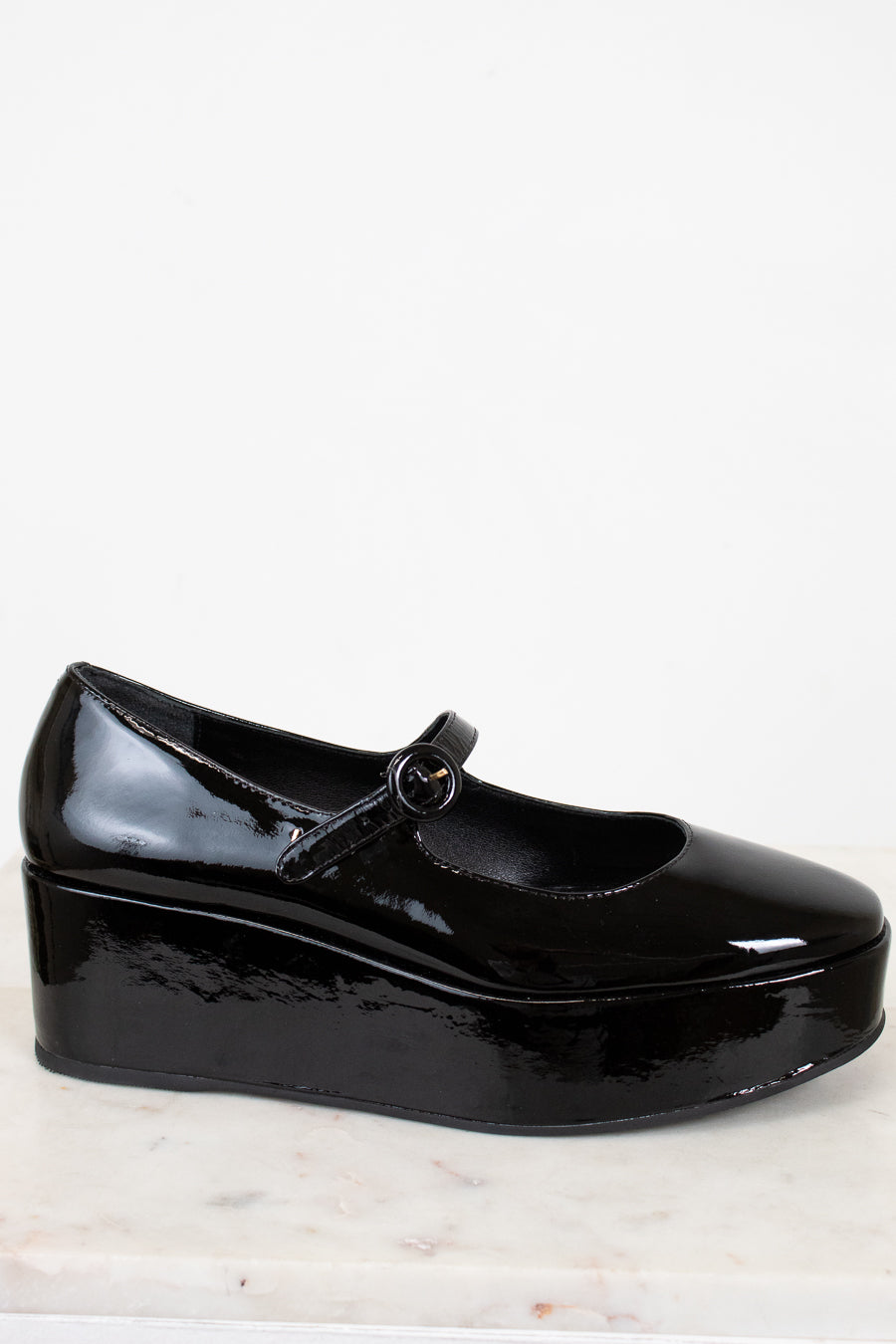 Black patent leather shoe on a light background
